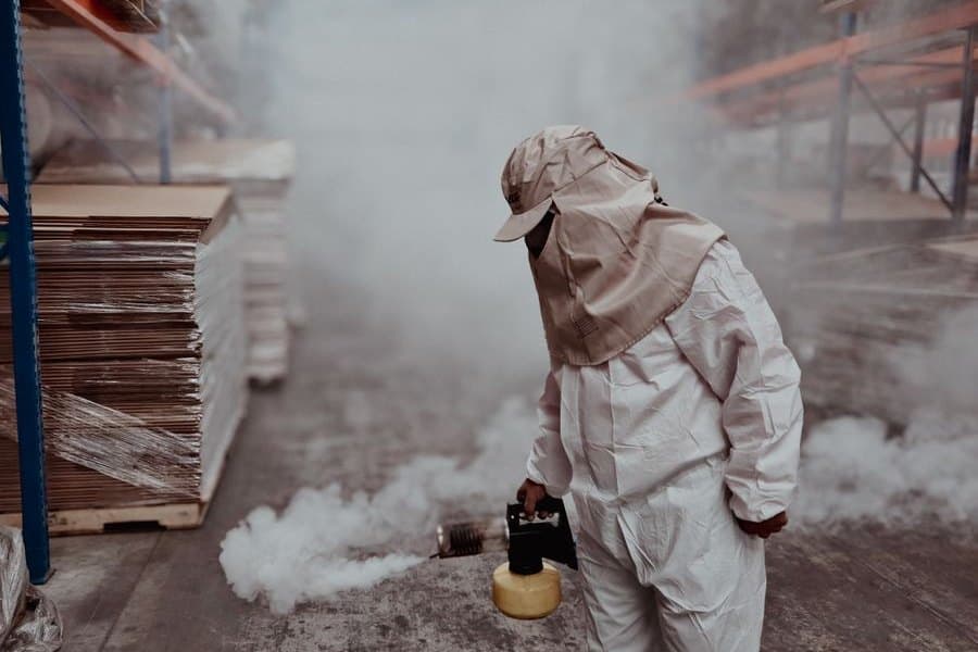 A technician treating a property in protective equipment
