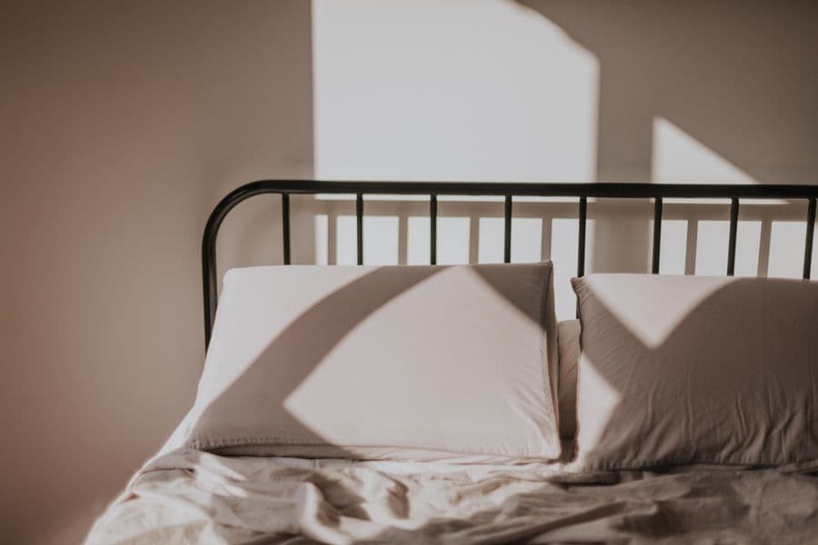 A made bed, showing the mattress seams and frame joints where bed bugs hide